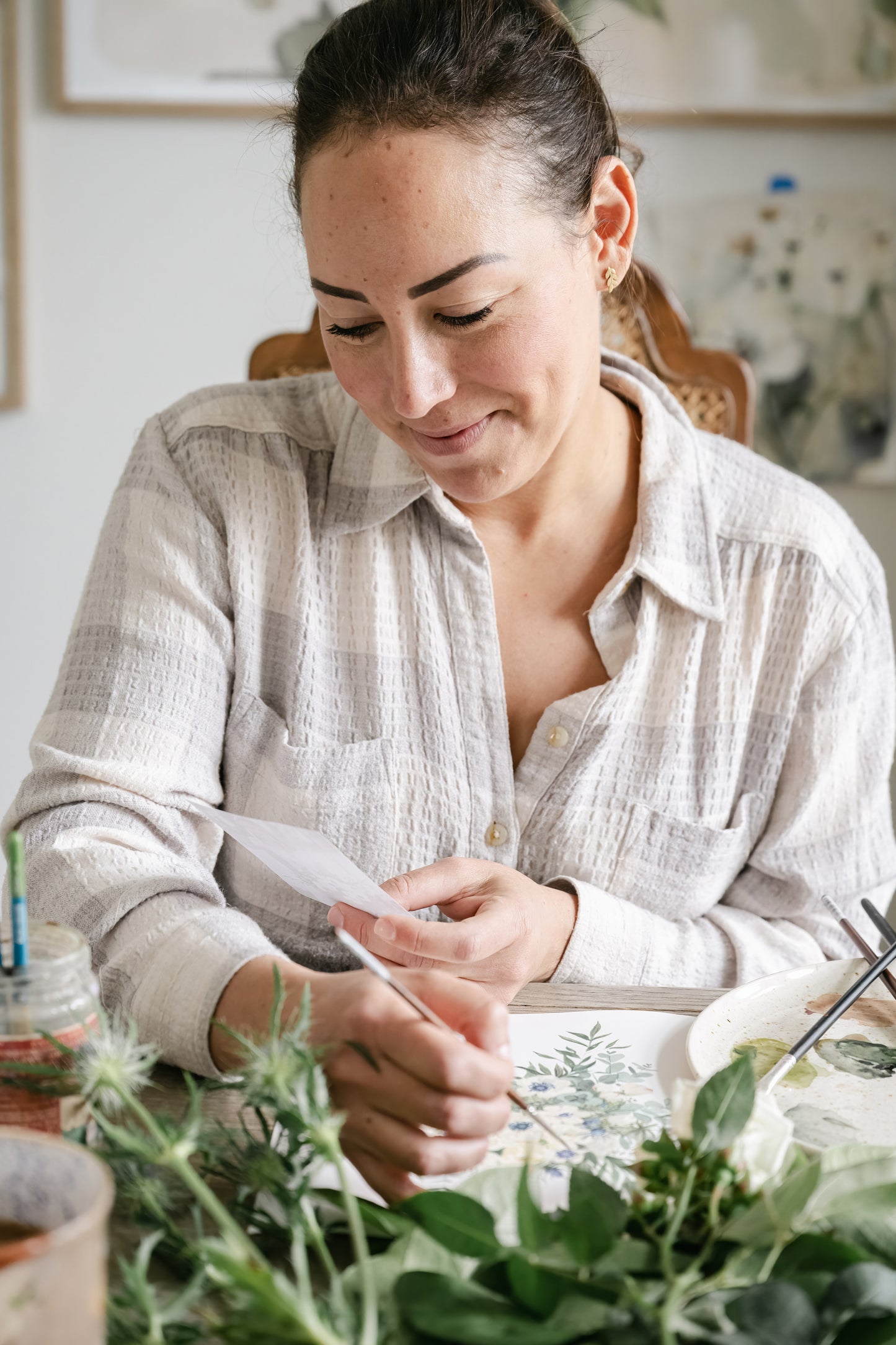 Artist Tonya Cruz in studio painting from inspiration image