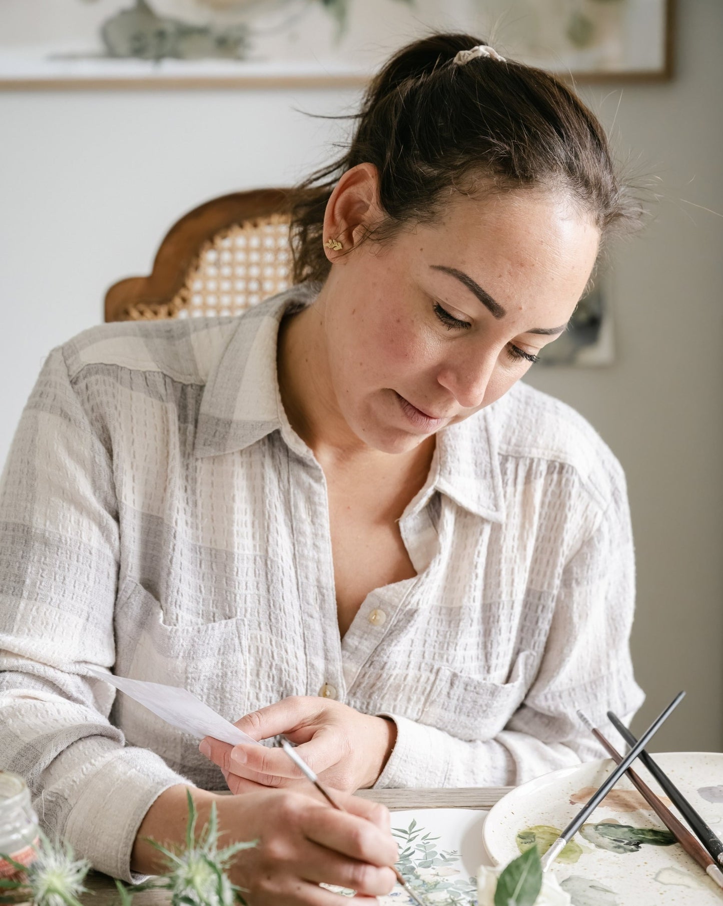 Artist Tonya Cruz in art studio painting from inspiration image